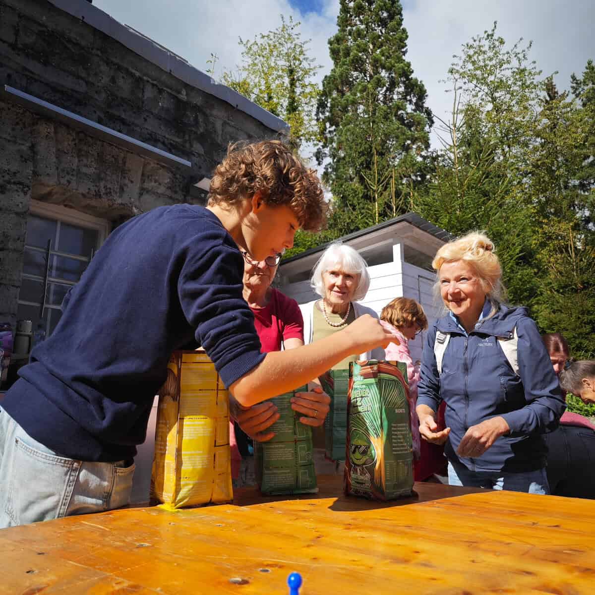 Pilz-Workshop: Junge Person hilft Senior beim Packen einer Züripilz-Pilzbox