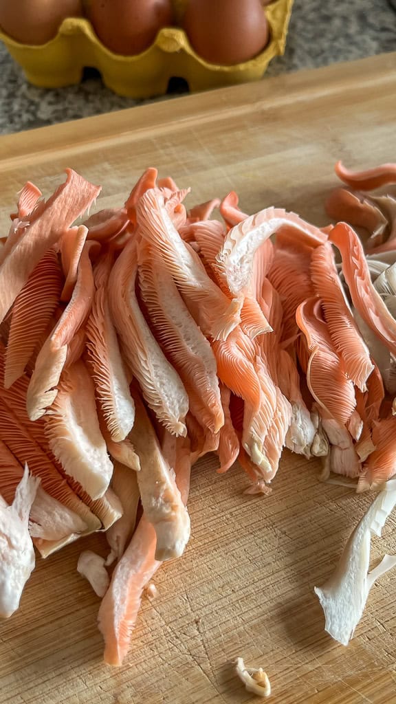 Austernseitlinge zubereiten – geschnittener Rosenseitling auf Holzbrett, trocken vorbereitet